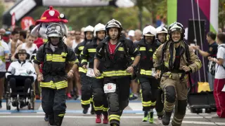 Imagen de los bomberos, con el equipo a cuestas, durante la 10K Bomberos de Zaragoza.