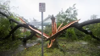Los equipos de rescate retirando el árbol que ha caído sobre una vivienda de Carolina del Norte.