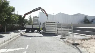 Los operarios descargan las planchas que conformarán el edificio modular que se levantará en el campus de San Francisco