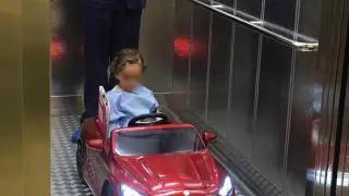 Un niño se dirige a quirófano en un coche teledirigido.