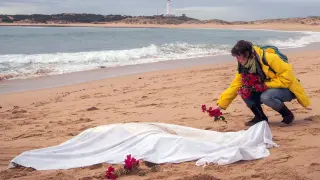 Una mujer deposita flores junto a uno de los cadáveres recuperados.
