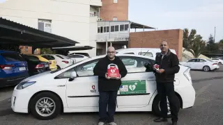 Javier Burgos, a la izquierda, y Ángel Hernández, muestran el desfibrilador instalado en el taxi 'cardioprotegido'.