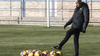Víctor Fernández, pensativo, juguetea con los balones al inicio del entrenamiento.