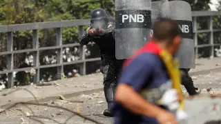 Un Policía disparando pelotas de goma a un manifestante en Carcas.