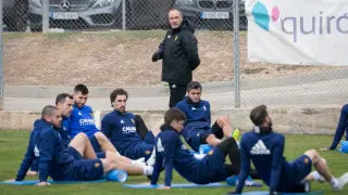 La plantilla del Zaragoza, bajo la mirada de Victor Fernández, estira en el entrenamiento de ayer en la Ciudad Deportiva.