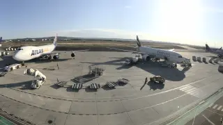 Panorámica de la plataforma de estacionamiento del aeropuerto, con varios aviones de mercancías y uno de pasajeros.
