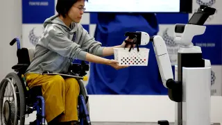 Toyota's Human Support Robot (HSR) delivers a basket to a woman in a wheelchair at a demonstration of Tokyo 2020 Robot Project for Tokyo 2020 Olympic Games in Tokyo, Japan, March 15, 2019. REUTERS/Kim Kyung-hoon [[[REUTERS VOCENTO]]] OLYMPICS-2020/ROBOTS