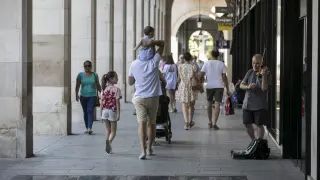 Un padre pasea con sus hijos por Zaragoza.