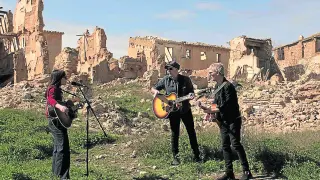 Eva Amaral y Juan Aguirre, junto a Ariel Rot, tocando en las ruinas de Belchite.