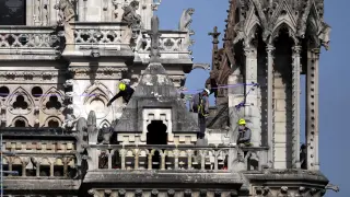 Los bomberos inspeccionan la fachada de la catedral de Notre Dame tras el incendio sufrido el lunes.