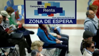 Unos ciudadanos esperan en una delegación madrileña para ser elaborar la declaración de la renta en la campaña pasada.