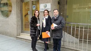 Jara Bernués, Lourdes Guillén y José Luis Cadena ante la fachada de la Colegio de Médicos de Huesca.