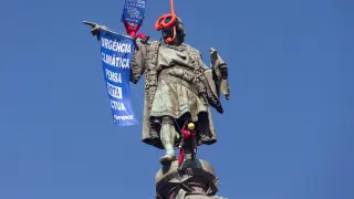 Dos activistas de Greenpeace colocan gafas de buzo a la estatua de Colón para protestar contra el cambio climático.