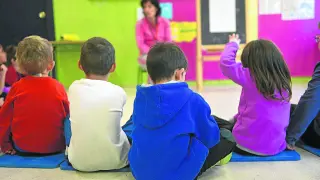 Niños pequeños atienden las explicaciones de la maestra en un colegio de Zaragoza.