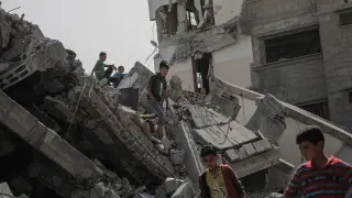 Varios niños jugando entre las ruinas de un edificio en Gaza