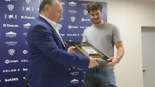 El presidente de la SD Huesca , Agustín Lasaosa, le entrega una placa conmemorativa a Gonzalo Melero.