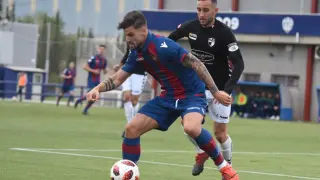 Un jugador del Levante B defiende ante la presión de un rival del CD Ebro.