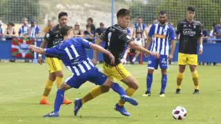 Sergio Sánchez intenta zafarse de un jugador del Alavés B