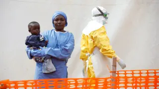 FILE PHOTO: Mwamini Kahindo, an Ebola survivor working as a caregiver to babies who are confirmed Ebola cases, holds an infant outside the red zone at the Ebola treatment centre in Butembo, Democratic Republic of Congo, March 25, 2019. REUTERS/Baz Ratner/File Photo [[[REUTERS VOCENTO]]] HEALTH-EBOLA/SOCIETY