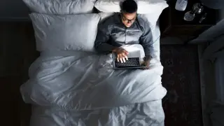 Man on bed using his laptop