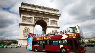 FILE PHOTO: Tourists ride in an open-air double-decker bus past the Arc de Triomphe in Paris, France, May 30, 2017. REUTERS/Charles Platiau/File Photo [[[REUTERS VOCENTO]]] FRANCE-TOURISM/