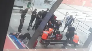 Los sanitarios tratan de reanimar al hombre. A la izquierda, uno de los policías agredidos, tumbado en el suelo.