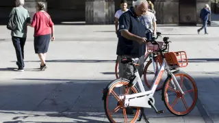 Un usuario de las bicicletas de Mobike, en la plaza del Pilar de Zaragoza.