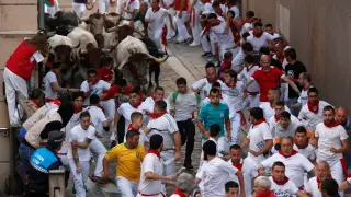 A reveller lays on the ground near bulls and steers during the running of the bulls at the San Fermin festival in Pamplona, Spain, July 11, 2019. REUTERS/Jon Nazca [[[REUTERS VOCENTO]]] SPAIN-CULTURE/BULLS