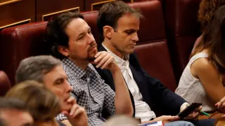 Pablo Iglesias escucha la intervención de Pablo Casado en el hemiciclo.
