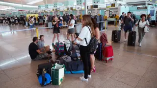 arias personas esperan este sábado frente los mostradores de la aerolínea Vueling