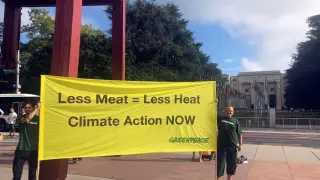 Dos miembros de Greenpeace despliegan una pancarta en Ginebra.