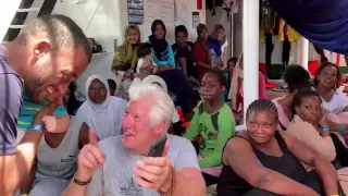 El actor Richard Gere habla con un migrante rescatado a bordo del Open Arms.