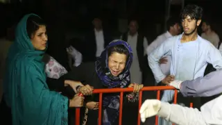 Una mujer llora mientras los servicios sanitarios atienden a familiares afectados por la explosión