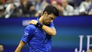 Djokovic tocando su hombro lesionado durante el partido