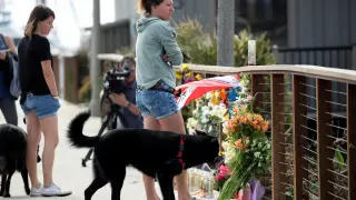 Ciudadanos californianos muestran su respeto ante las flores colocadas por las víctimas del incendio en el barco.