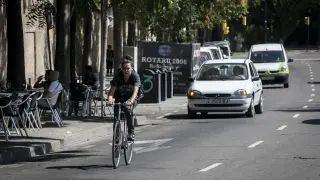 Una ciclista circula entre coches por la calle Asalto.