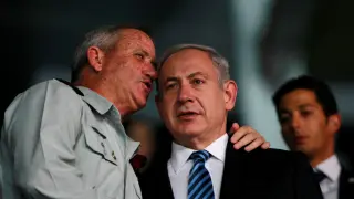 Benny Gantz (i) y Benyamin Netanyahu (d) conversando durante la ceremonia.