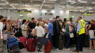 Largas filas de pasajeros y clientes de la agencia de viajes Thomas Cook en el aeropuerto de Mallorca tras el cierre de la compañía.
