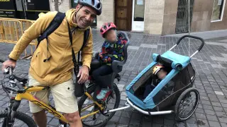 José Antonio Julián, llevando a sus hijos de 3 y 5 años en una silla y en un carro acoplados a la bici.