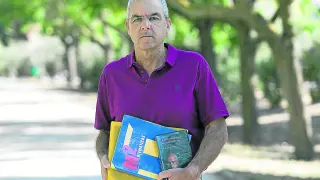 Fernando de la Cueva, este lunes, con el libro de Matemáticas (azul) que ha repartido y otros materiales.