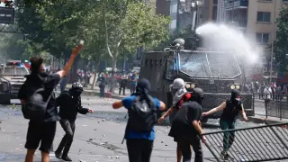 Manifestantes se enfrentan con la policía durante el sexto día de protestas contra el Gobierno