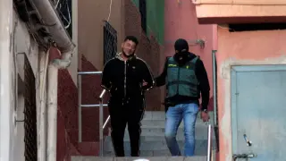 Un miembro de la Guardia Civil con uno de los detenidos durante la operación contra el tráfico de drogas y de inmigrantes que se ha iniciado en Ceuta y que se extiende a otras localidades, como Algeciras y Málaga.