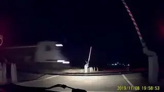 Un conductor frena ante la barrera levantada segundos antes de que pase el tren.