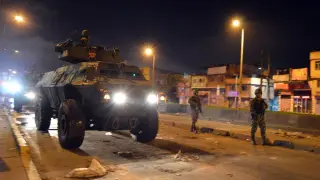 Militares en un tanque y a pie patrullan por las calles de un barrio de Bogotá como se puede ver en esta foto cedida por el Ejército de este país.