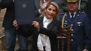 La presidenta interina de Bolivia, Jeanine Áñez, sostiene un documento durante la promulgación de una ley de urgencia este domingo en La Paz.