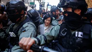 La policía escolta a una de las legisladoras prochinas en Hong Kong