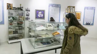 Una joven contempla una vitrina con libros y documentos expuestos