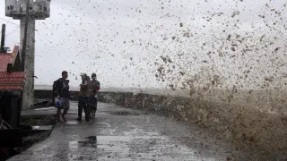 Habitantes de Calabanga, en Filipinas, ven las altas olas que presagian la llegada del tifón