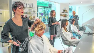 Varias trabajadoras atienden a sus clientas en una peluquería.