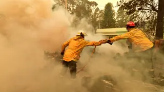 Werombi (Australia), 06/12/2019.- Firefighters hose down a burning woodpile during a bushfire in Werombi, 50km south west of Sydney, Australia, 06 December 2019. (Incendio) EFE/EPA/MICK TSIKAS AUSTRALIA AND NEW ZEALAND OUT Bushfires continue to burn in New South Wales, Australia